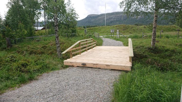 Bron över Vallgravsbäcken. I bakgrunden syns jordvallarna runt Skansen, flaggstången och berget Långåknätten.